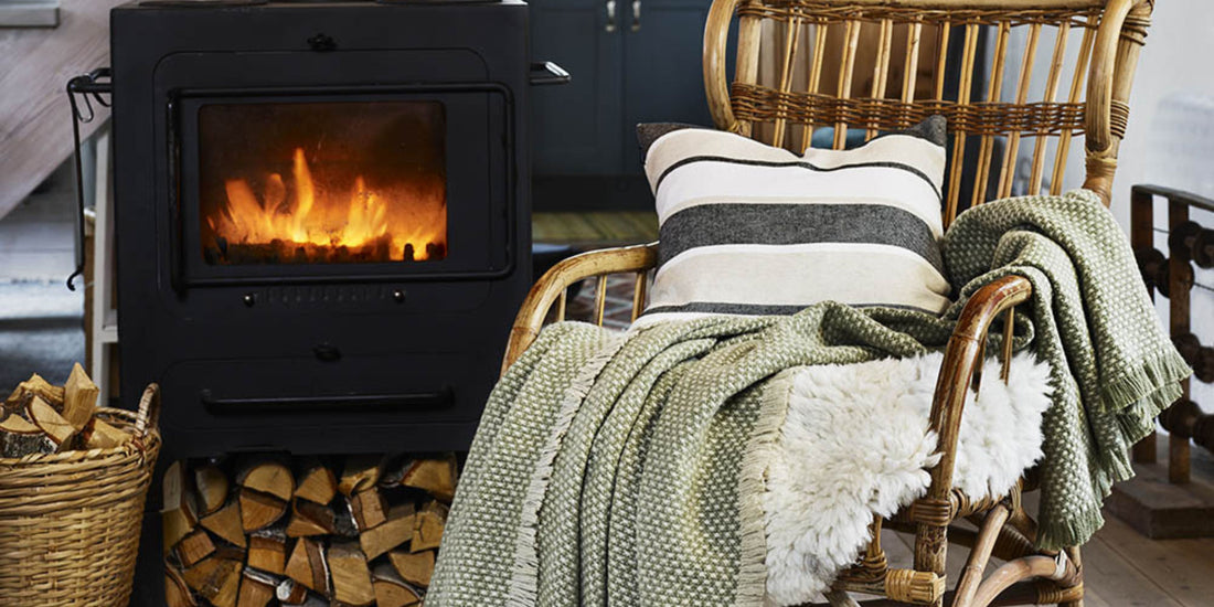 Klippan Blanket on a chair next to a roaring log fire